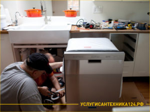 Два мастера подключают посудомоечную машину